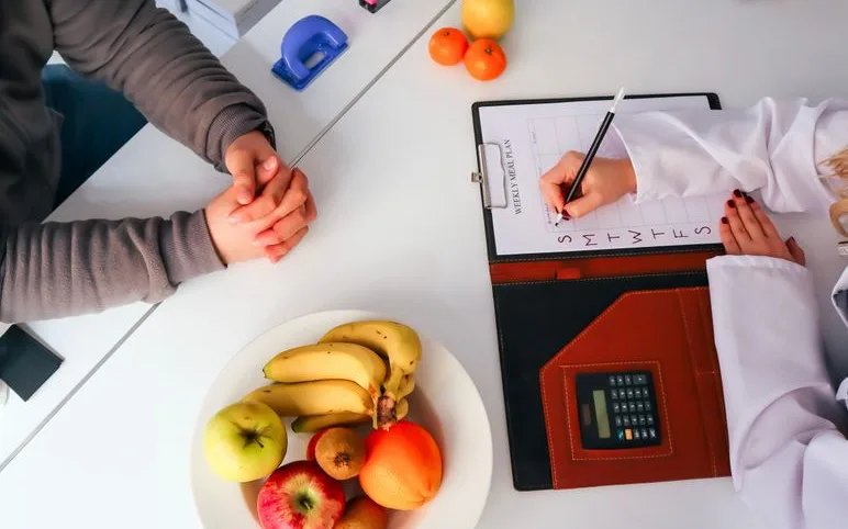 Fruits frais et carnet de planification des repas sur une table de travail